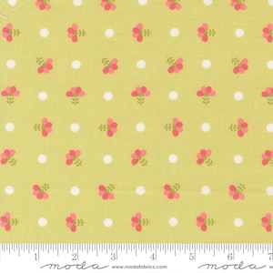 May include: A light green fabric with a repeating pattern of pink flowers and white polka dots. The flowers have green stems and leaves. The fabric is marked with a ruler in inches.
