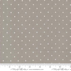 May include: A close-up of a fabric with a gray background and white polka dots. The fabric has a ruler along the bottom edge. The fabric is likely cotton or a similar material.