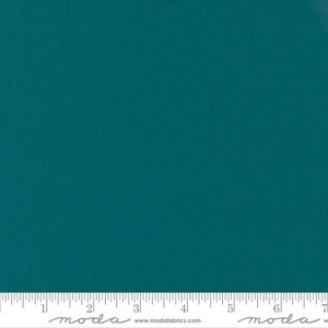May include: A solid teal fabric swatch with a subtle texture. The fabric is measured in inches with the text "moda" printed on the ruler.