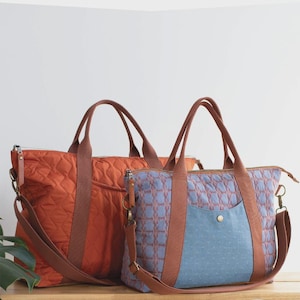 May include: Two tote bags with brown handles and straps. The orange tote has a quilted pattern. The blue tote has a geometric pattern with a blue pocket. The text "OXBOW TOTE" is at the top, with "a zip top tote in two sizes (regular & overnight)" below it.
