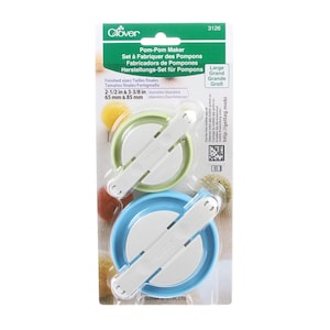 May include: A Clover brand pom-pom maker set in original packaging. Includes one light green and one blue circular plastic tool with white hinged arms. Text indicates finished sizes of 2-1/2 inches and 3-3/8 inches. Model number 3126.