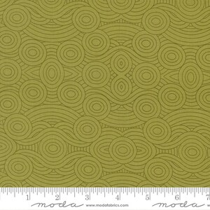 May include: Olive green fabric with a repeating pattern of concentric circles and curved lines. The design creates a wave-like effect across the fabric. The fabric has a ruler along the bottom edge with the word "moda" printed on it.