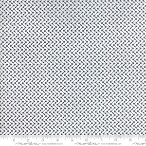 May include: A white fabric featuring a repeating geometric pattern of dark navy blue squares connected by thin lines and small navy blue ovals. A white ruler with black markings and the text moda www.modafabrics.com is visible at the bottom.