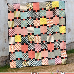 May include: A colorful patchwork quilt with the word "Beaded" in script. The quilt features squares of various patterns and colors, including floral, plaid, and striped designs. Black and coral accents separate the squares. The Running Doe Quilts logo is at the bottom.