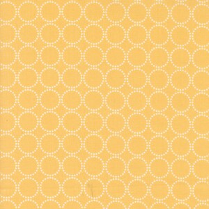 May include: A close-up of a fabric with a repeating pattern of white dotted circles on a yellow background. The circles are evenly spaced and create a visually appealing design. The fabric has a slightly textured appearance.