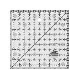 May include: A clear, square quilting ruler with black markings and a diagonal line. The ruler has a grid pattern with measurements in inches and the text "Itty-Bitty Eights Square". The brand name "creative grids" is also visible.