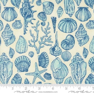 May include: Cream-colored fabric with a repeating pattern of blue seashells, starfish, and coral. The design features various shell shapes and sizes, creating a nautical theme. The word "moda" is printed at the bottom.
