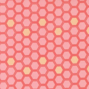 May include: A close-up of a fabric with a honeycomb pattern. The design features coral-colored outlines and light pink hexagons, with occasional yellow hexagons. The fabric has a textured appearance.