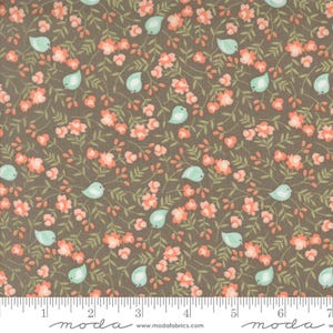 May include: A fabric with a repeating pattern of coral-colored flowers, light green leaves, and light blue birds on a brown background. The fabric has a ruler along the bottom edge with the word "moda" printed on it.
