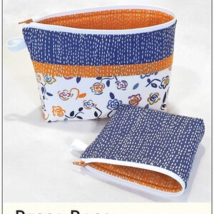 May include: Two zippered pouches, one larger than the other, with a floral print and a blue and white patterned fabric. The pouches are open and the zippers are visible. The text "Becca Bags" is at the bottom of the image. The text "Handy best friends to stow and go. These big-mouth bags quietly stand open for easy access. Zipper goes in straight and flat, then bend and easily add the pull. Two sizes. www.LazyGirlDesigns.com" is also included.