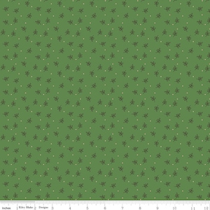 May include: Green fabric with a repeating pattern of small brown leaves and tiny off-white dots. The leaves are delicate and evenly spaced across the surface. The fabric is marked with a ruler in inches.