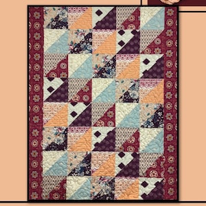 May include: Quilt pattern titled "Hanover" by Villa Rosa Designs. The quilt features a patchwork design with a variety of floral prints in shades of pink, blue, and brown. The quilt is bordered with a red and white floral print.