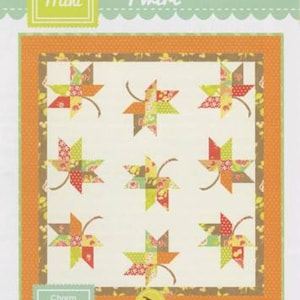 May include: A quilt pattern titled "Twirl" featuring a repeating design of colorful, stylized leaf shapes. The leaves are composed of patchwork squares in shades of orange, green, red, and cream. The pattern is labeled "Mini" and "Charm Square Friendly".