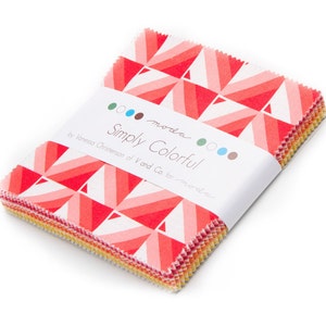 May include: A stack of fabric squares with a geometric pattern in shades of red, pink, and white. The fabric is wrapped with a white label that reads "Simply Colorful" by Vanessa Christenson of V and Co. for Moda.