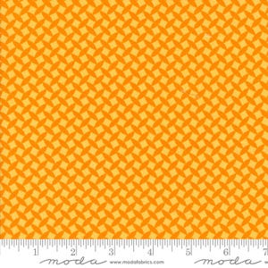 May include: Close-up of a fabric with a repeating pattern of orange oval shapes on a yellow background. The fabric has a ruler along the bottom edge with the word "moda" and the website address www.modafabrics.com.