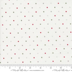 May include: White fabric with a repeating pattern of red, green, and gray polka dots. The dots are evenly spaced across the surface. The fabric has a ruler printed along the bottom edge, with the word "moda" printed at the bottom.