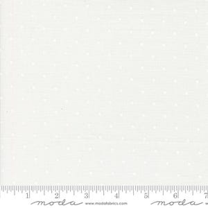 May include: White fabric with a subtle polka dot pattern. The fabric has a ruler printed along the bottom edge, with measurements in inches. The fabric is from Moda Fabrics.