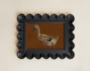 May include: A framed print of a duck. The artwork features a detailed depiction of a duck with tan and black feathers, set against a brown background. The frame is black with a wavy, scalloped edge, adding a decorative touch to the piece.