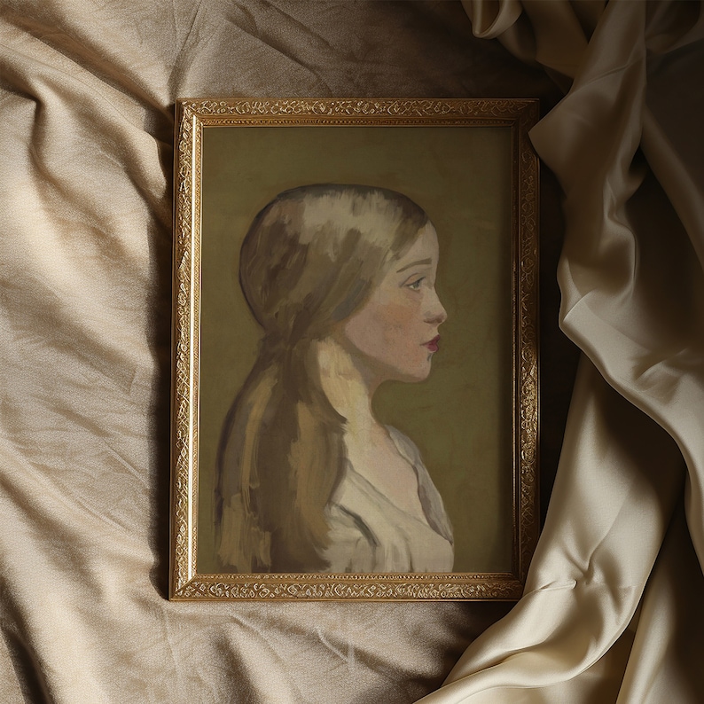 a portrait of a girl in neutral colours is in a gold gilded frame on beige silk