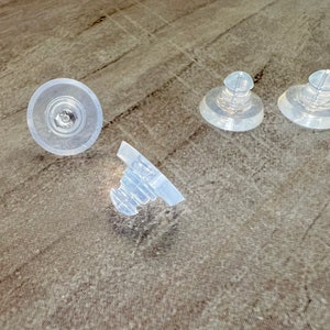 May include: Four clear plastic suction cups, two are round and two are dome shaped.