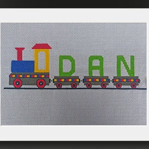 May include: A colorful train with the name "DAN" spelled out in green letters on the cars. The train is made of felt and is perfect for a child's room.