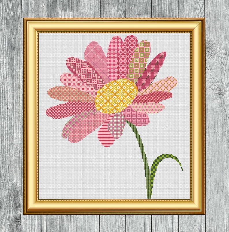 May include: A pink and yellow patchwork flower cross stitch pattern. The flower has a yellow center and pink petals with different patterns. The stem is green.