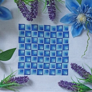May include: A blue and white cross-stitch pattern with a checkered design. The pattern is stitched on white Aida cloth.