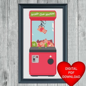 May include: A red and white pixel art style cross stitch pattern of a claw machine with the text "Arcade Claw Machine" at the top. The claw machine has three stuffed animals inside and one being lifted by the claw. The pattern is for a digital download.