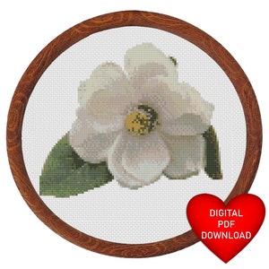 May include: A white camellia flower with green leaves, a cross-stitch pattern, in a brown wooden frame. The text "DIGITAL PDF DOWNLOAD" is on a red heart.