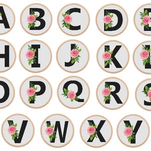 May include: A set of 27 embroidery hoops with black letters of the alphabet and ampersand, each surrounded by pink flowers and green leaves.