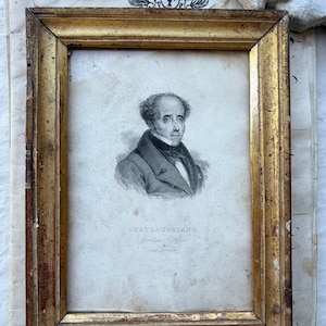 May include: An antique portrait print of a man in a gold gilded frame. The print is a black and white engraving with the name "Chateaubriand" at the bottom. The frame has a distressed, aged appearance.