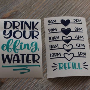 May include: Two white stickers with black and teal lettering. The first sticker says "Drink your effing water" with a teal squiggle underneath. The second sticker has a time tracker with black hearts and the text "REFILL" in teal.
