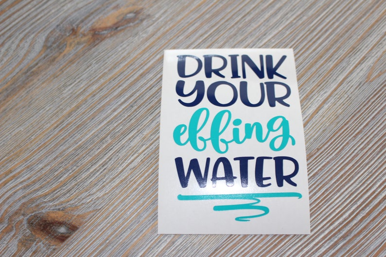 May include: White sticker with the text "Drink your effing water" in blue and turquoise lettering.