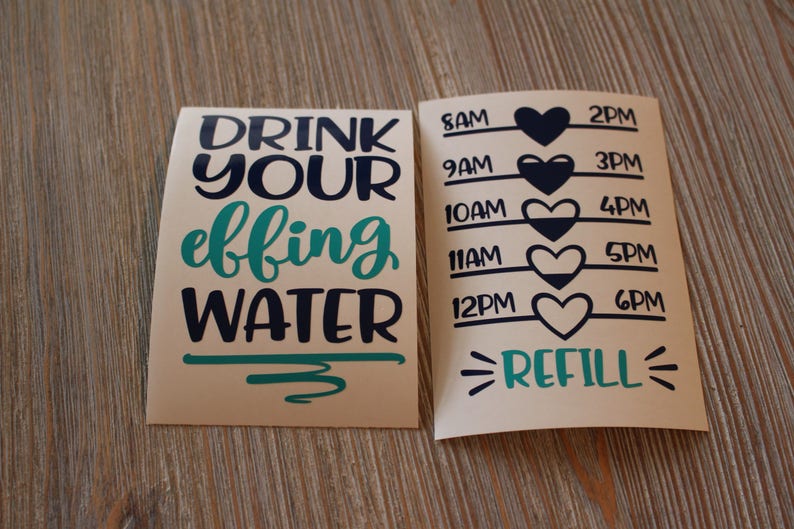 May include: Two beige paper sheets with black and teal text. The left sheet says "DRINK YOUR EFFING WATER". The right sheet has a water tracker with times from 8 AM to 6 PM and a heart icon next to each time. The bottom of the right sheet says "REFILL".