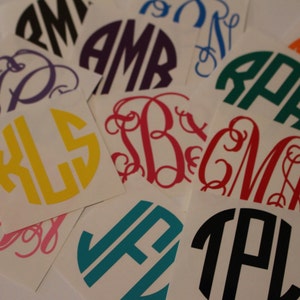 May include: Assortment of colorful monogram stickers with various letter combinations. The stickers are on white square backgrounds.
