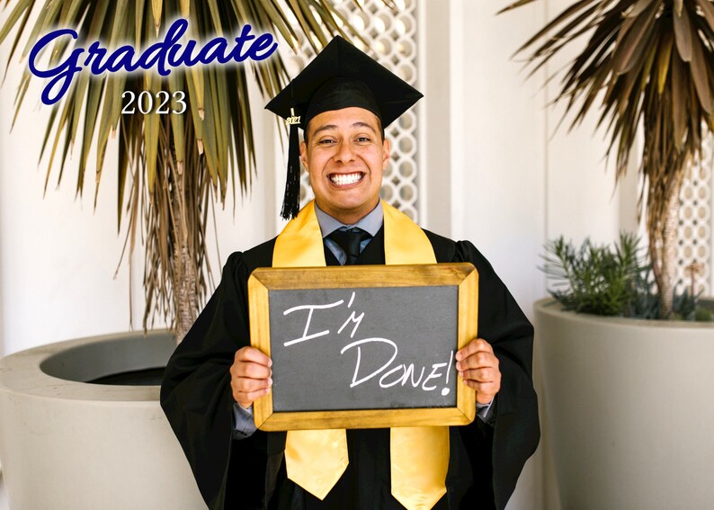 May include: A person wearing a black graduation cap and gown, holding a chalkboard with the words "I'm Done!" written on it. The person is smiling and has a yellow graduation sash.