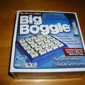 May include: The Classic Edition Big Boggle board game box. The box is white with blue accents and features a grid of lettered cubes. The game is advertised as a 3-minute word game for ages 8+.