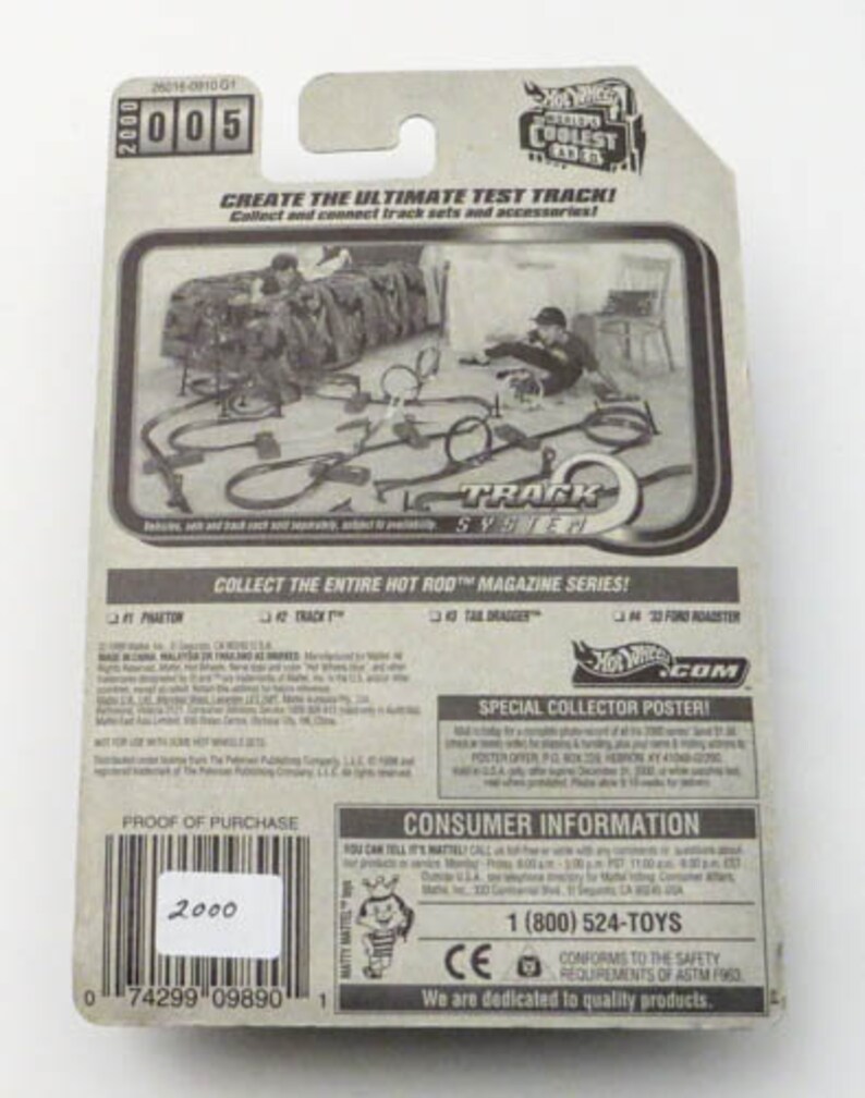 May include: A Hot Wheels Track System toy car packaging with a black and white image of a track set. The packaging features the text "Create the Ultimate Test Track!" and "Collect the entire Hot Rod Magazine Series!" The packaging also includes a special collector poster offer.
