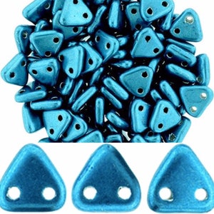 May include: A bulk bag of teal blue triangle shaped glass beads with two holes. The beads are metallic and have a shiny finish.