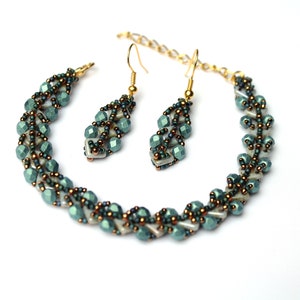 Könnte beinhalten: Ein Set aus tealfarbenen und weißen Perlenohrringen und einem Armband. Die Ohrringe sind im Hänge-Stil und das Armband ist eine zarte Kette.