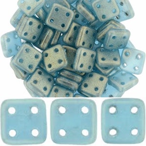 May include: A pile of light blue square glass beads with four holes each. The beads have a frosted finish and are approximately 6mm in size.