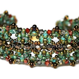 Puede incluir: Un brazalete de cuentas verdes, marrones y rojas con un diseño tejido. El brazalete está hecho con cuentas pequeñas e irregulares y tiene un patrón delicado e intrincado.