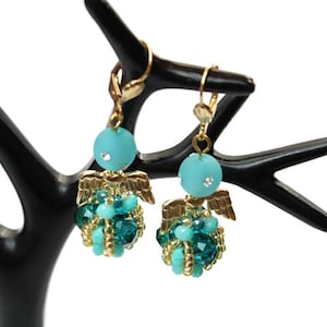 Könnte beinhalten: Ein Paar Ohrringe mit goldenen Engelsflügeln und türkisfarbenen und grünen Perlen.