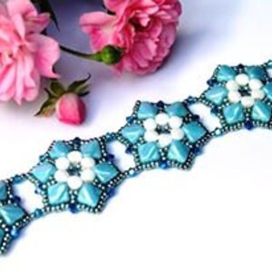 May include: A blue and white beaded bracelet with a geometric flower design. The bracelet is made with small, round beads and has a delicate, feminine look.