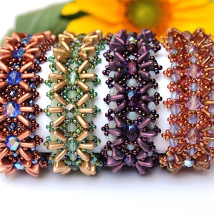 Könnte beinhalten: Fünf Perlenarmbänder in verschiedenen Farben, darunter Kupfer, Grün, Lila und Braun. Die Armbänder sind aus kleinen, filigranen Perlen gefertigt und haben ein geometrisches Muster.