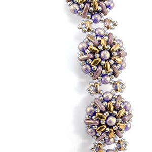 Könnte beinhalten: Ein lila-goldenes Armband mit einem Starman Trendsetters Logo und dem Namen Olga Haserodt. Das Armband besteht aus kleinen Perlen in einem Blumenmuster.