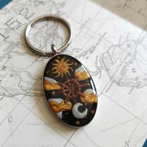 Llavero hecho a mano con diseño de tarot de la Rueda de la Fortuna