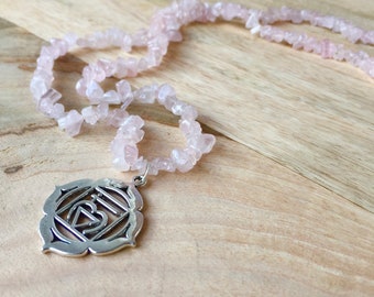 Rosenquarz Halskette mit einem silbernen Wurzel-Chakra Anhänger. Eine lange, perlenbesetzte Kette, tolles Geschenk für Frauen