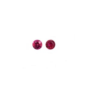 May include: Two small, round, faceted rubies with a deep red color. Each gemstone features a circular cut with multiple facets that reflect light, creating a brilliant appearance. These loose stones are presented against a plain white background.