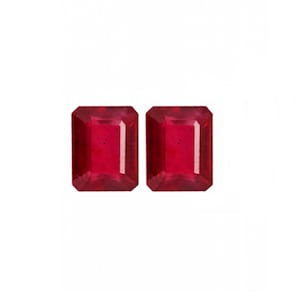May include: Two red emerald cut gemstones.